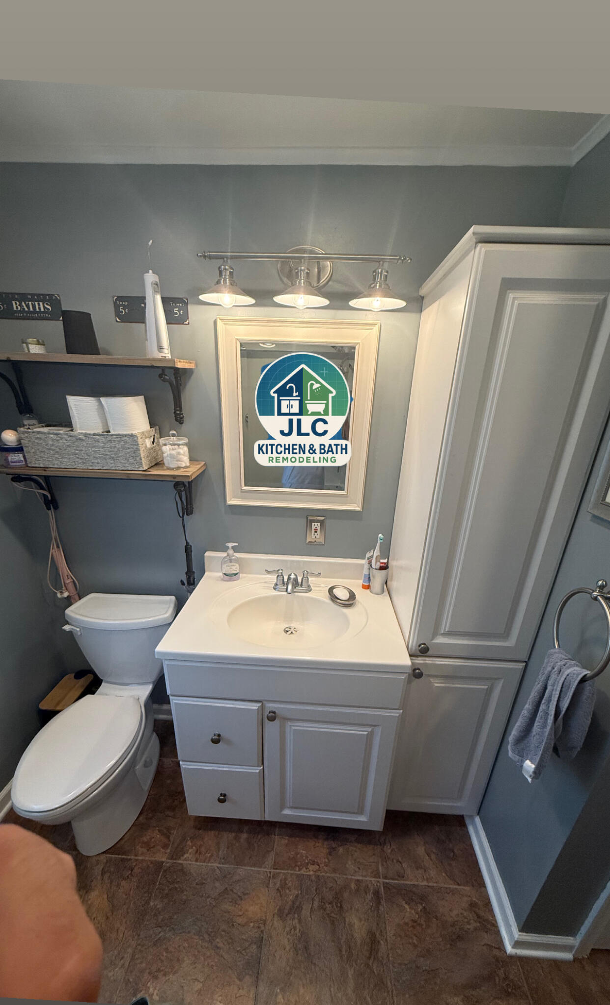 JLC Kitchen & Bath Remodeling Bathroom vanity with white cabinet, framed mirror and three-light fixture